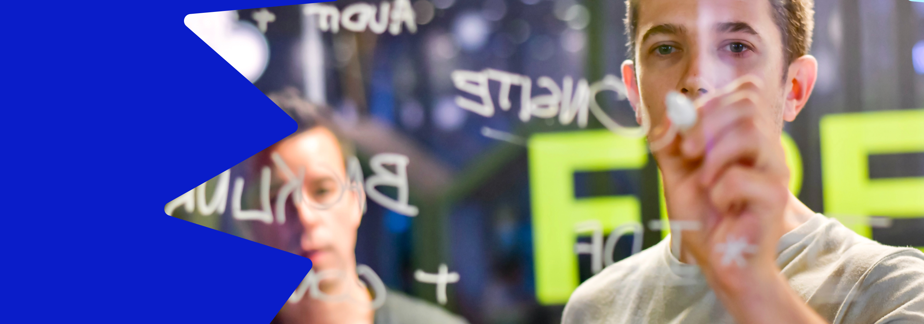 Image of a man writing on clear glass using a white marker